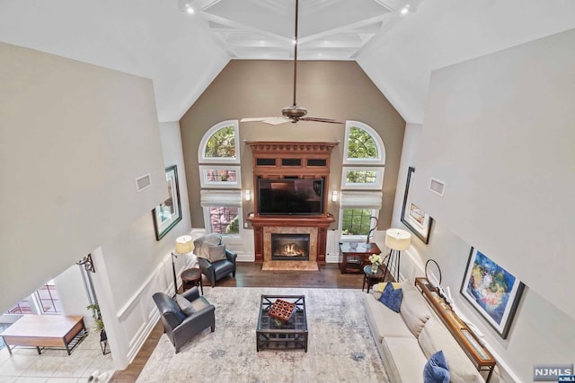 living room with hardwood / wood-style floors, high vaulted ceiling, and plenty of natural light