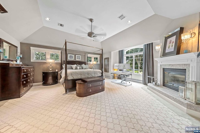 carpeted bedroom with ceiling fan, lofted ceiling, and a premium fireplace