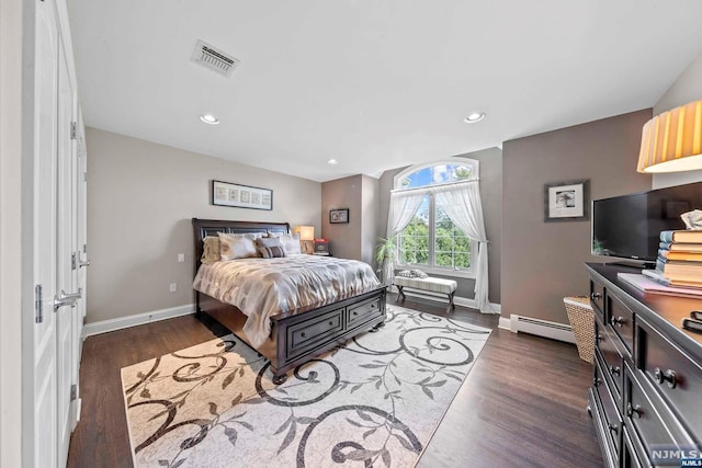 bedroom with baseboard heating and dark wood-type flooring