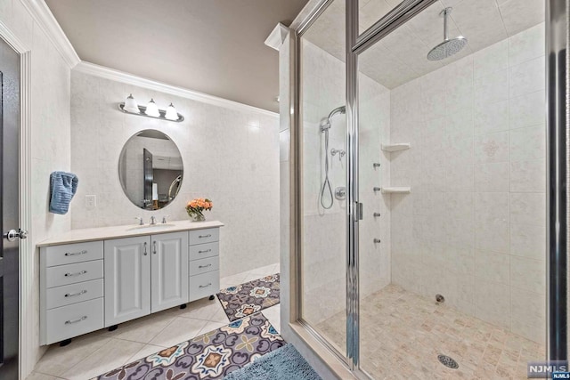 bathroom with tile patterned floors, a shower with door, vanity, and ornamental molding