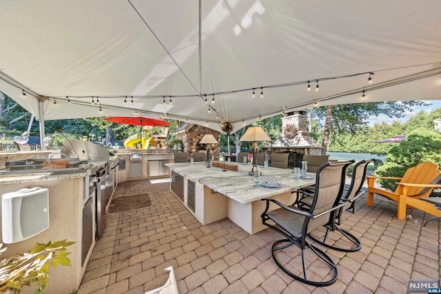 view of patio featuring exterior bar and an outdoor kitchen