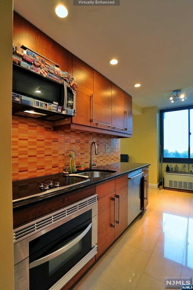 kitchen with sink, light tile patterned floors, backsplash, and appliances with stainless steel finishes