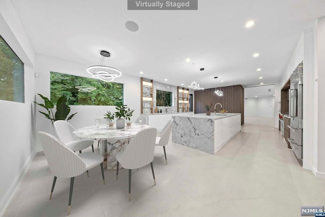 dining space featuring sink and an inviting chandelier