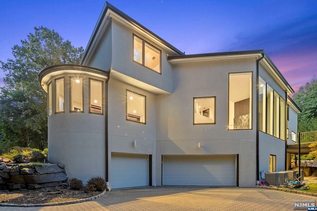 contemporary house featuring central AC unit and a garage