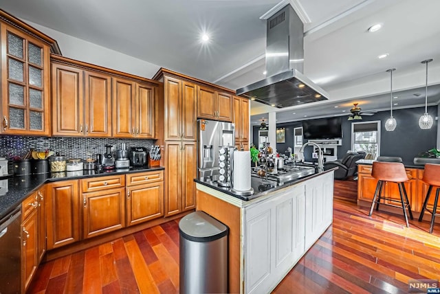 kitchen featuring island exhaust hood, appliances with stainless steel finishes, ceiling fan, pendant lighting, and dark hardwood / wood-style floors