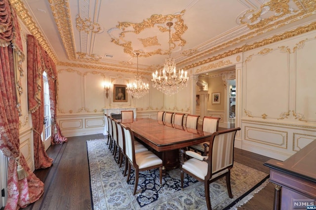 dining area with dark hardwood / wood-style floors, crown molding, and an inviting chandelier