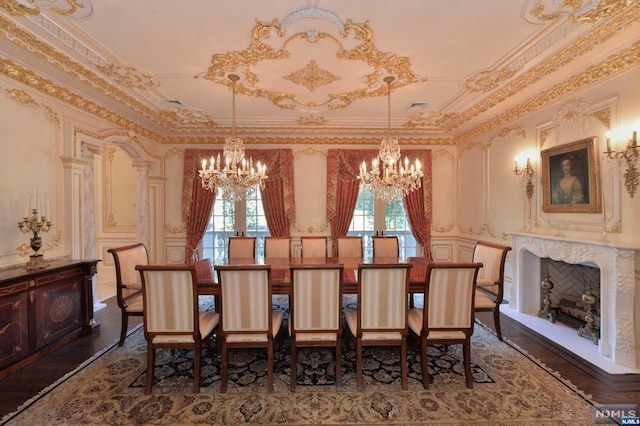 dining space featuring a chandelier, dark hardwood / wood-style flooring, crown molding, and a premium fireplace