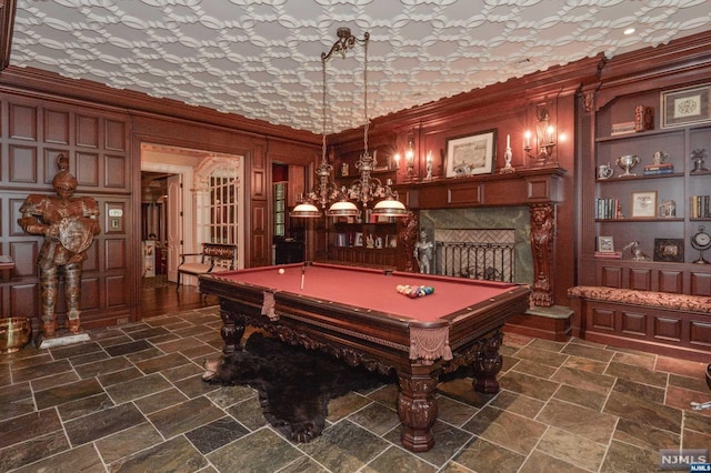 recreation room featuring built in shelves, crown molding, and pool table