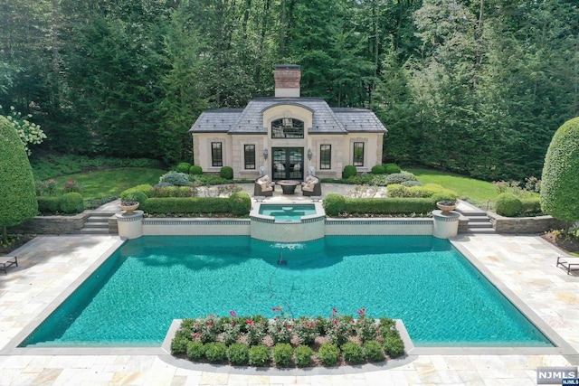 view of swimming pool featuring an in ground hot tub, a patio area, and an outdoor structure