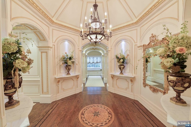 interior space featuring crown molding, a towering ceiling, and dark wood-type flooring