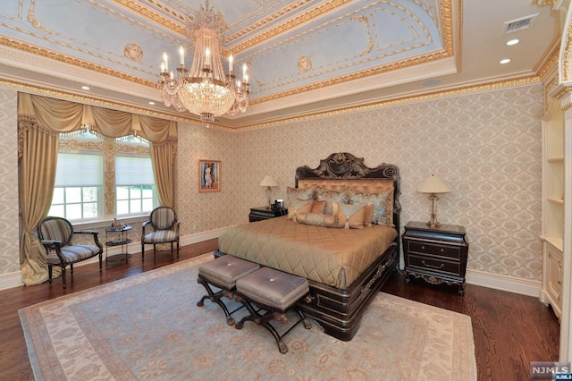 bedroom featuring ornamental molding, a tray ceiling, and dark wood-type flooring