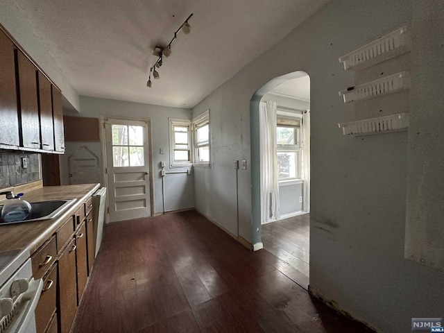 kitchen with dishwasher, track lighting, dark wood-type flooring, and sink