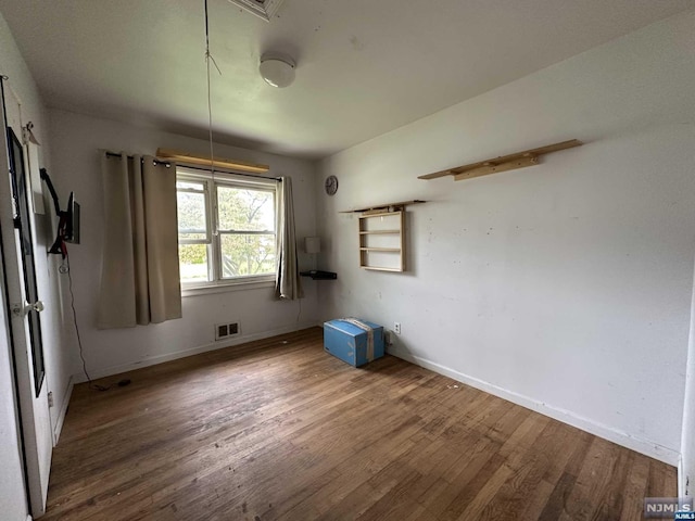 unfurnished room with hardwood / wood-style floors