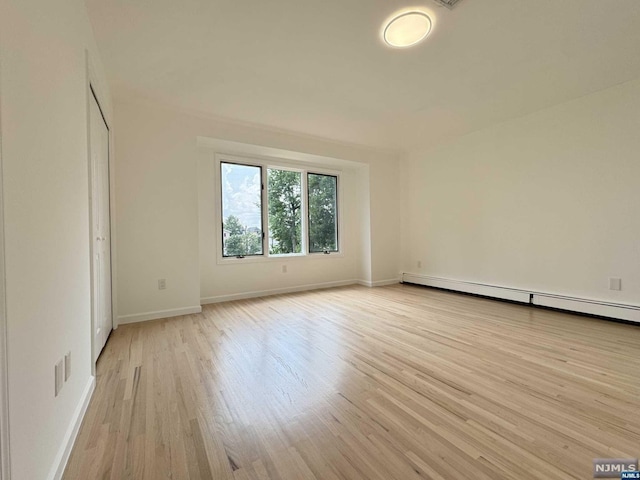 spare room with light hardwood / wood-style flooring and a baseboard heating unit