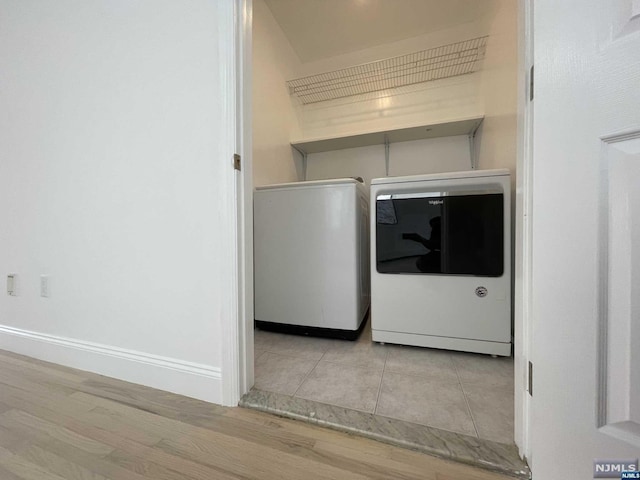 washroom with washer and clothes dryer and light hardwood / wood-style flooring