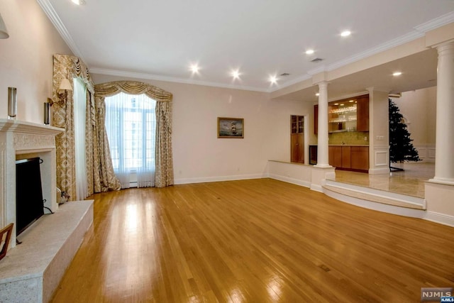 unfurnished living room featuring light hardwood / wood-style floors, ornamental molding, and a fireplace