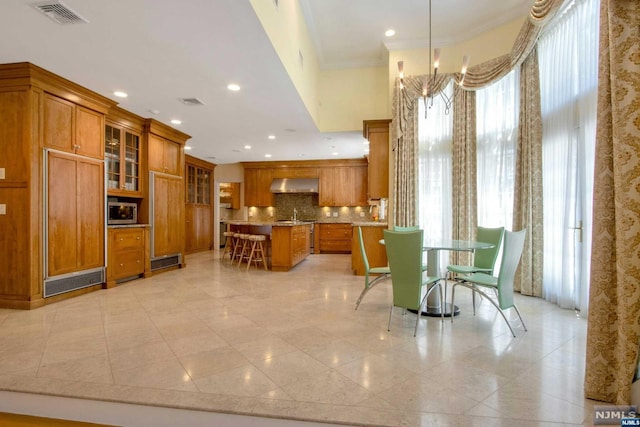 dining space featuring a wealth of natural light, crown molding, and sink