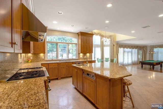 kitchen with sink, billiards, an island with sink, a kitchen bar, and exhaust hood