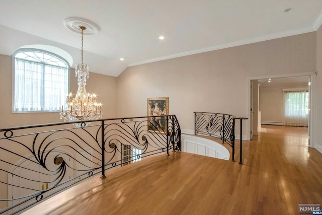 hallway with lofted ceiling, crown molding, baseboard heating, a notable chandelier, and wood-type flooring