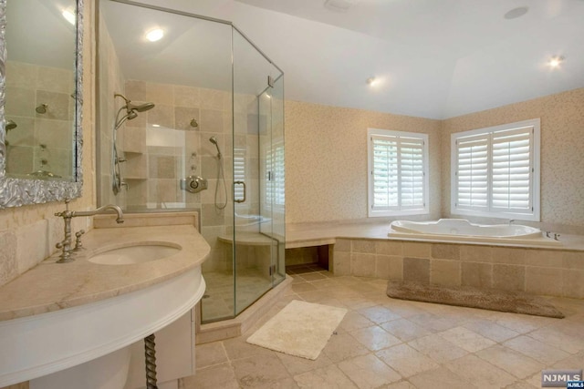 bathroom featuring tile patterned flooring, shower with separate bathtub, vaulted ceiling, and sink