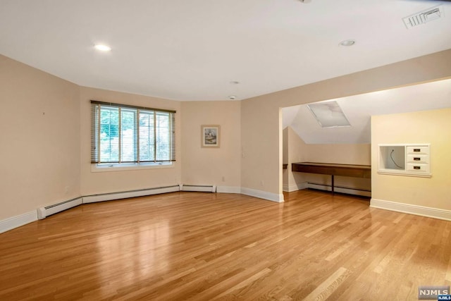 interior space with light hardwood / wood-style flooring and a baseboard heating unit