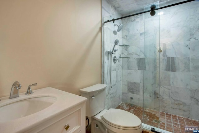 bathroom with an enclosed shower, vanity, and toilet