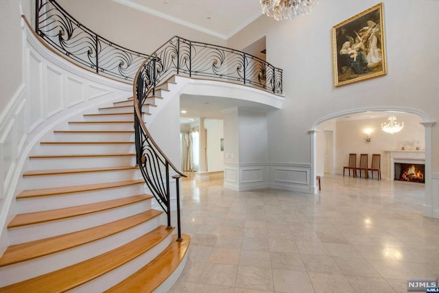 stairs featuring a high ceiling and ornamental molding