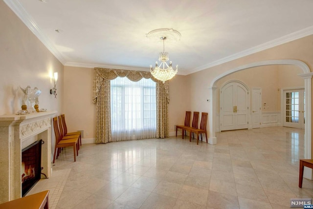 sitting room with an inviting chandelier, crown molding, and a tiled fireplace