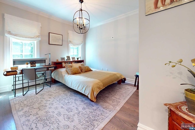 bedroom with a chandelier, hardwood / wood-style floors, baseboard heating, and crown molding