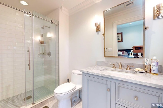 bathroom featuring crown molding, vanity, a shower with shower door, and toilet