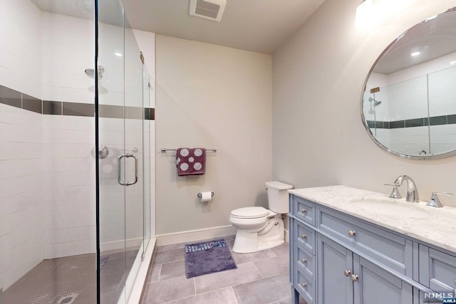 bathroom with tile patterned flooring, vanity, toilet, and a shower with shower door