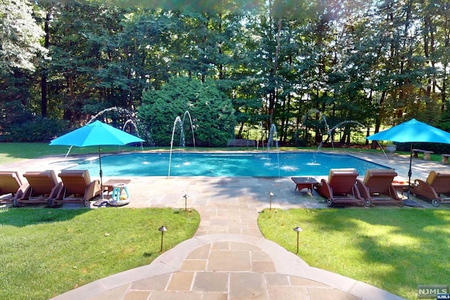 view of swimming pool featuring pool water feature, a patio area, and a lawn