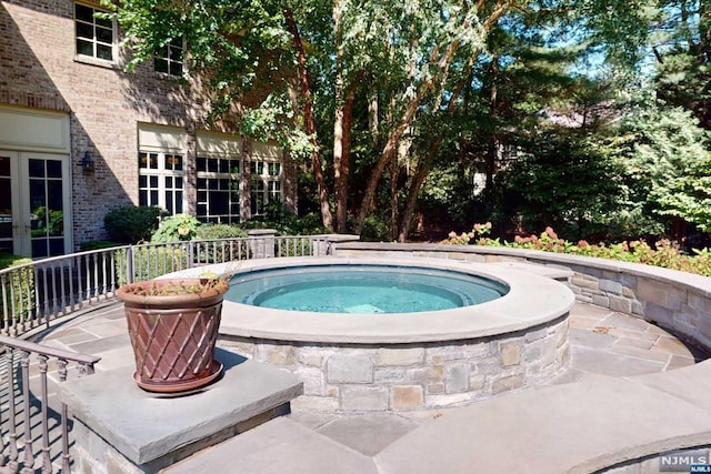 view of swimming pool with an in ground hot tub