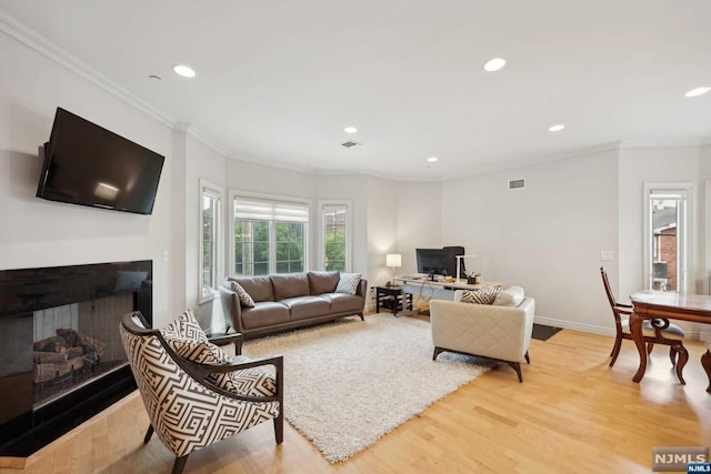 living room with light hardwood / wood-style floors and ornamental molding