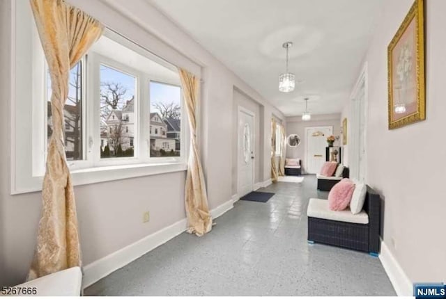 corridor with an inviting chandelier