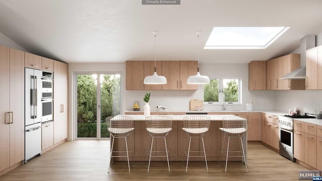 kitchen featuring pendant lighting, a breakfast bar, a center island, a skylight, and appliances with stainless steel finishes