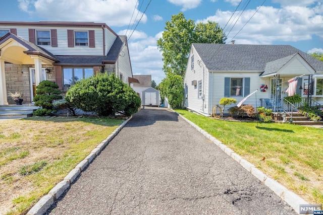 view of side of home featuring a lawn and a storage unit