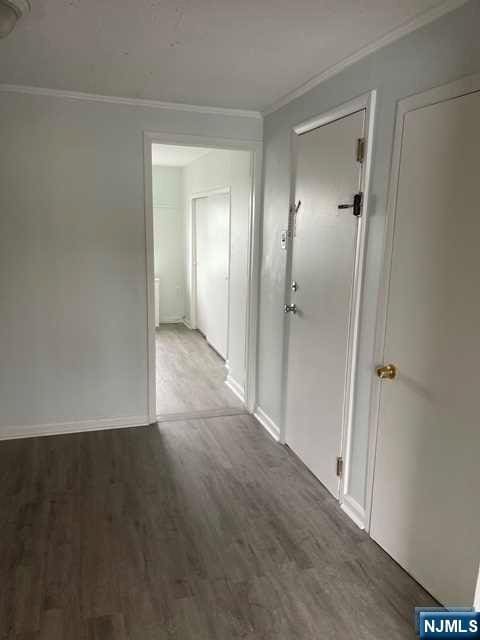 hall featuring hardwood / wood-style flooring and crown molding