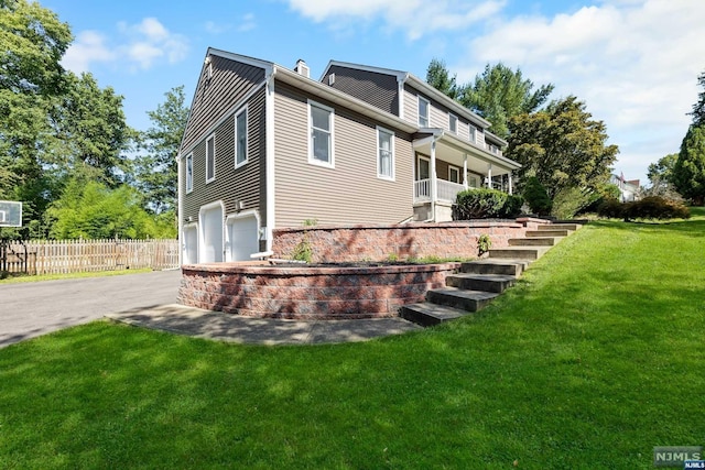 back of property featuring a yard and a garage