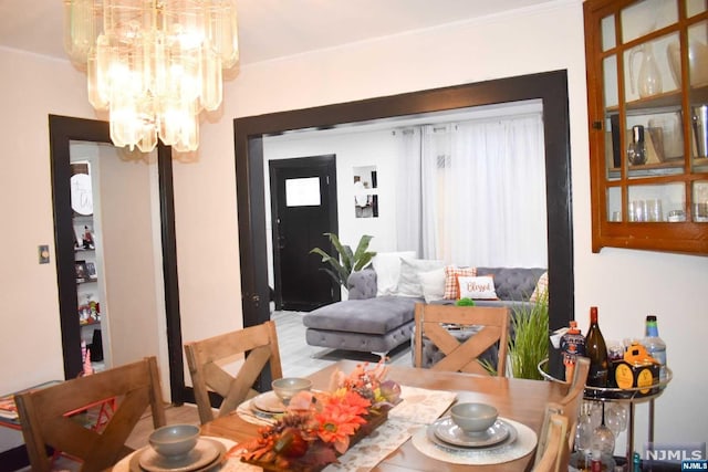 dining area with an inviting chandelier and ornamental molding