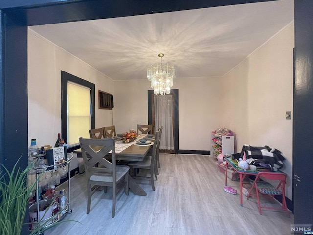 dining room featuring hardwood / wood-style floors, ornamental molding, and a chandelier