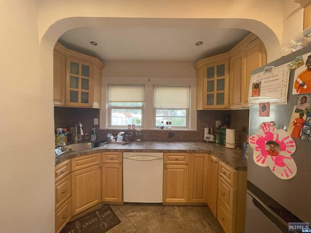 kitchen with dishwasher, stainless steel fridge, sink, and tasteful backsplash