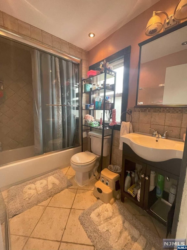 full bathroom with shower / tub combo, tile patterned floors, sink, tile walls, and toilet