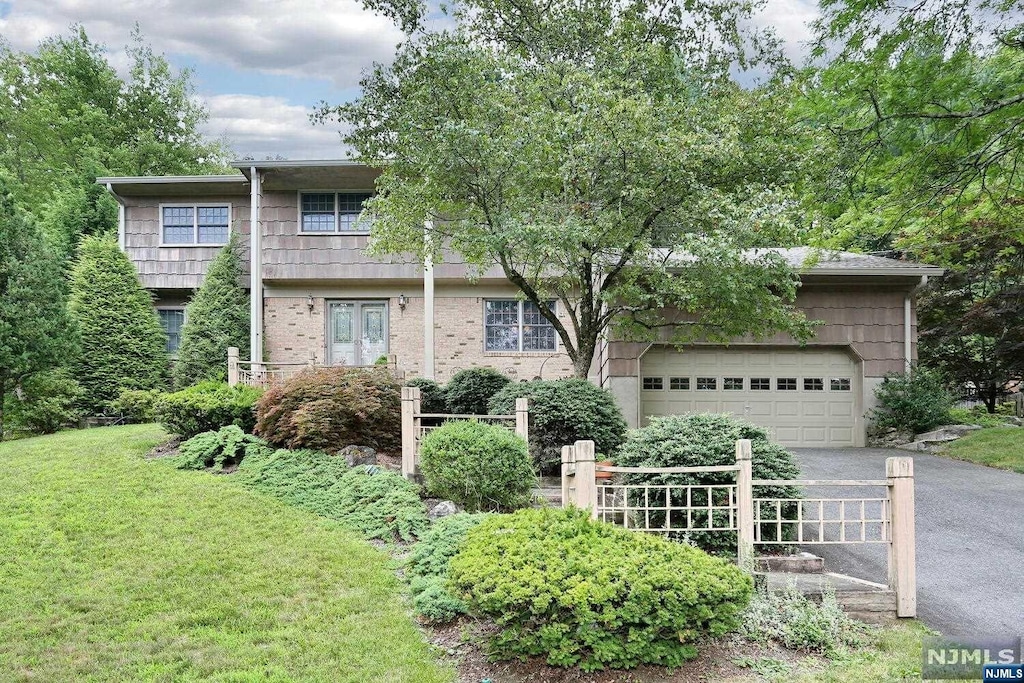 view of front of home with a garage and a front lawn