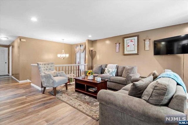 living room with hardwood / wood-style flooring and an inviting chandelier