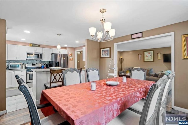 dining space featuring light hardwood / wood-style floors and an inviting chandelier