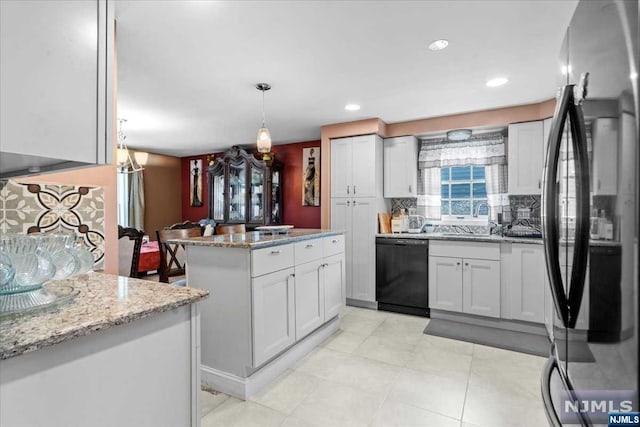 kitchen featuring stainless steel fridge, backsplash, white cabinets, dishwasher, and hanging light fixtures