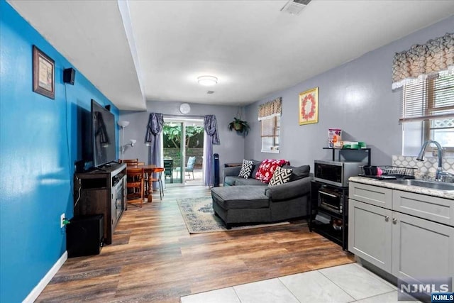 living room with light hardwood / wood-style floors and sink