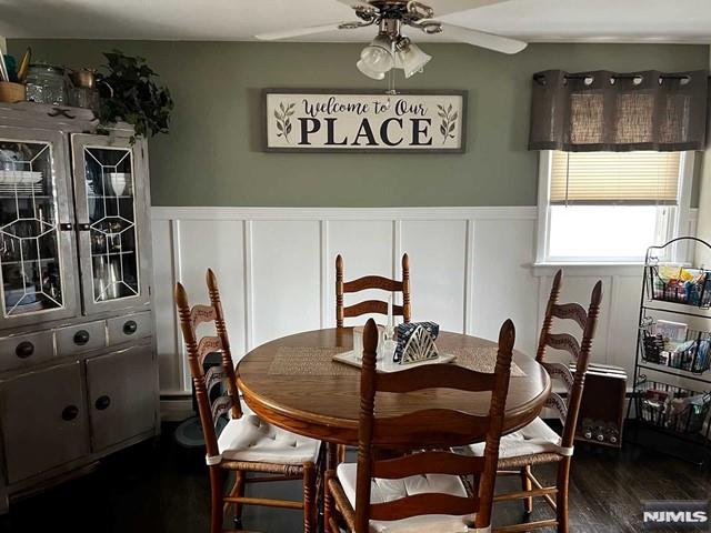 dining room with ceiling fan and dark wood-type flooring