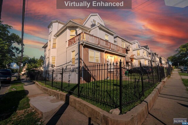property exterior at dusk featuring a balcony